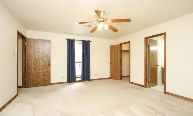 a view of a livingroom with a chandelier fan and a window