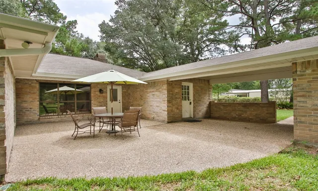 a view of a patio with table and chairs under an umbrella
