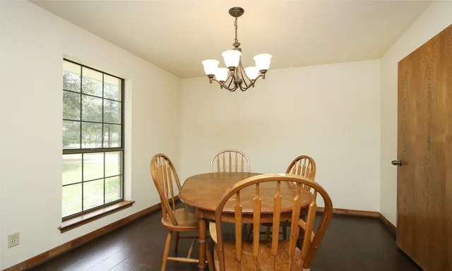 a dining room with furniture a window and wooden floor