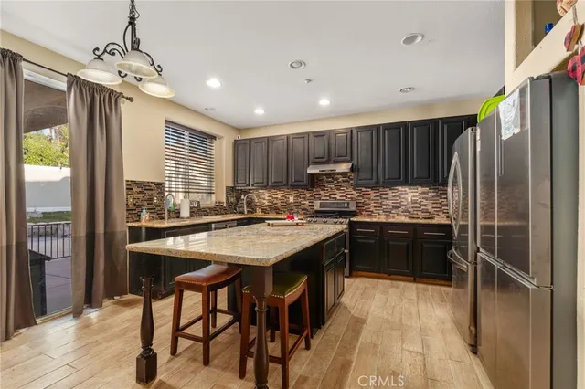 a kitchen with kitchen island granite countertop wooden cabinets a center island and stainless steel appliances