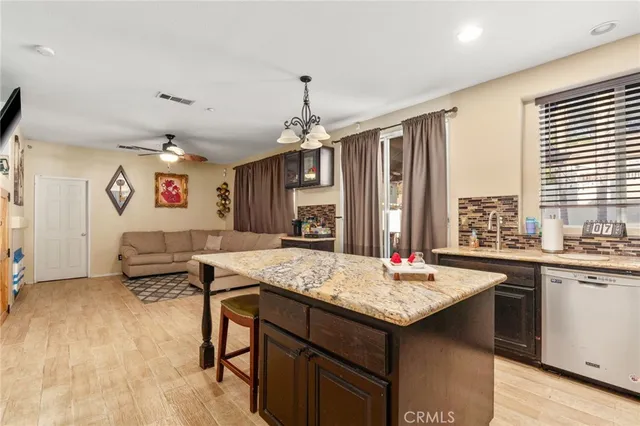 a kitchen with a stove a sink dishwasher and a refrigerator with wooden floor