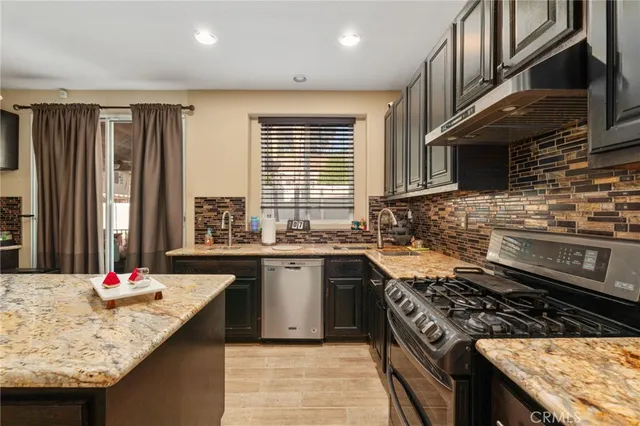 a kitchen with kitchen island granite countertop a sink stove and cabinets