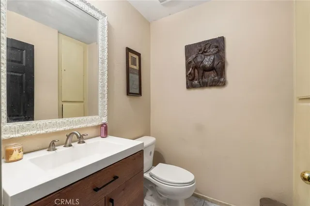 a bathroom with a toilet sink vanity and mirror