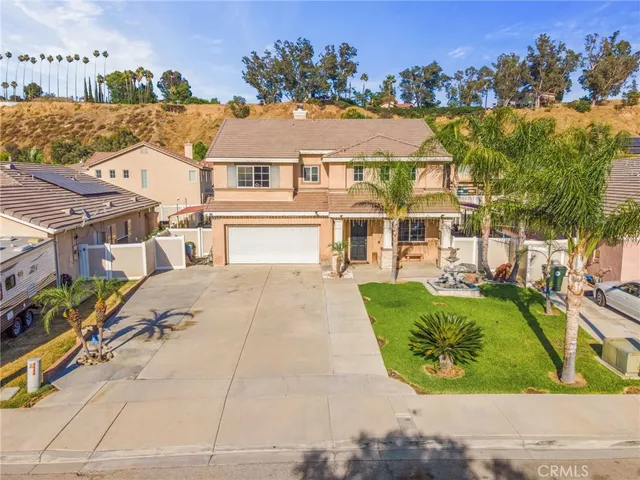 a front view of a house with a yard and potted plants