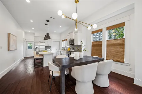 a kitchen with stainless steel appliances a stove a sink a center island and wooden floor