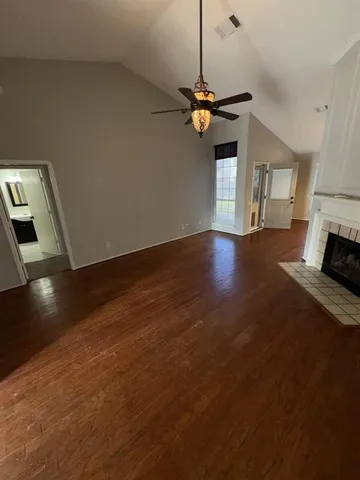 a view of a room with wooden floor and a ceiling fan