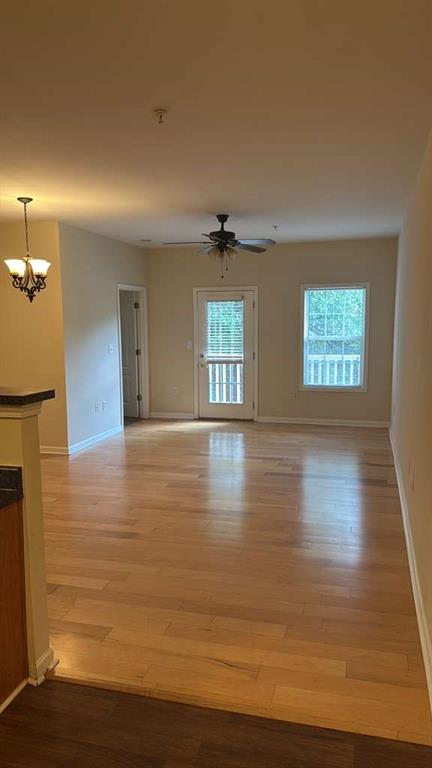 a view of an empty room with window and wooden floor