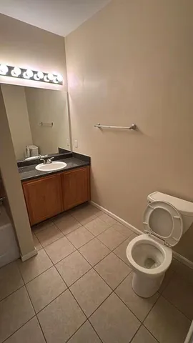 a bathroom with a sink mirror vanity and toilet