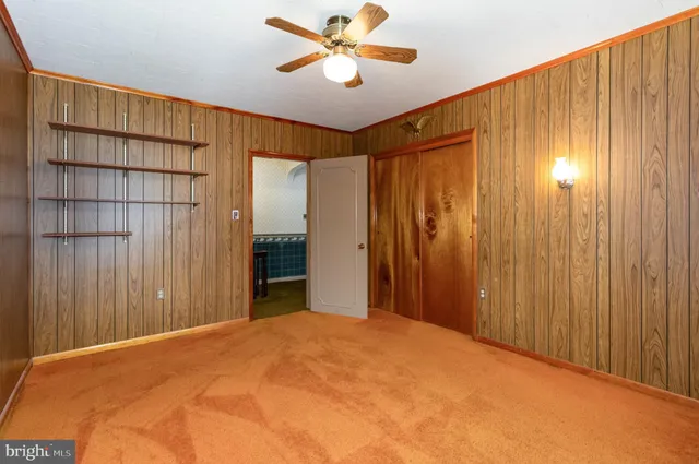 a bedroom with a bed and a chandelier fan