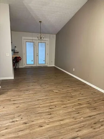 a view of a room with wooden floor and windows