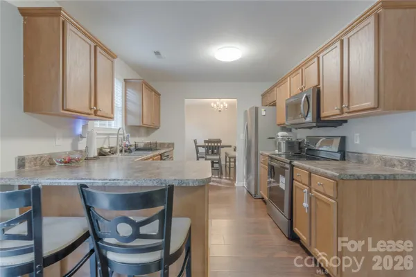 a kitchen with stainless steel appliances granite countertop a sink stove and cabinets