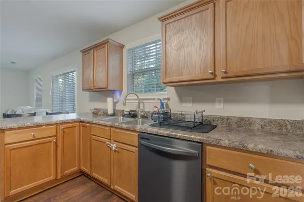 a kitchen with granite countertop stainless steel appliances white cabinets sink and dishwasher