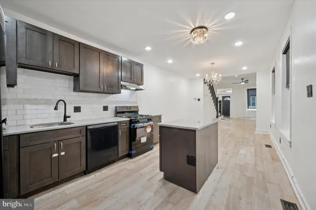 a large kitchen with stainless steel appliances lots of counter space and a sink
