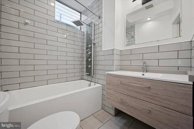 a bathroom with a sink a toilet and bathtub