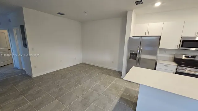 a kitchen with stainless steel appliances a refrigerator and microwave