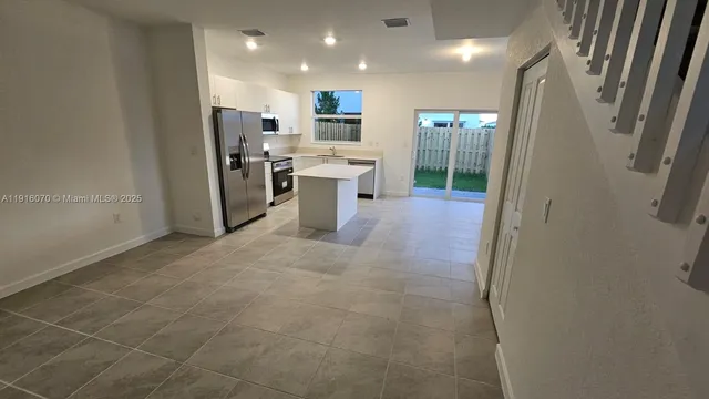 a view of a kitchen with stainless steel appliances a refrigerator and a counter top space