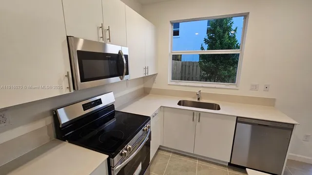 a kitchen with a sink and a stove top oven