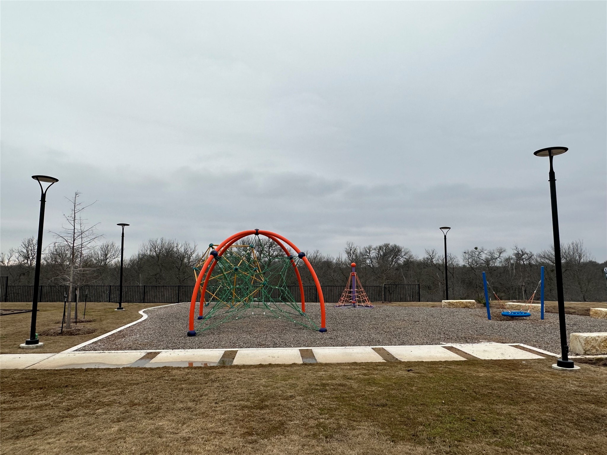 13501 Mussel Run Elgin, TX 78621 - Photo 22 of 28 Recreational area featuring a climbing structure, swings, and a stone-bordered pathway
