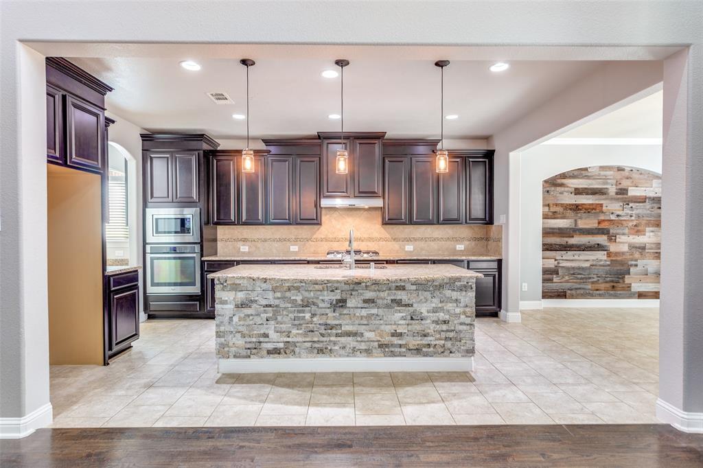 1505 5th Street Argyle, TX 76226 - Photo 10 of 25 a large kitchen with granite countertop a refrigerator oven a sink and dishwasher
