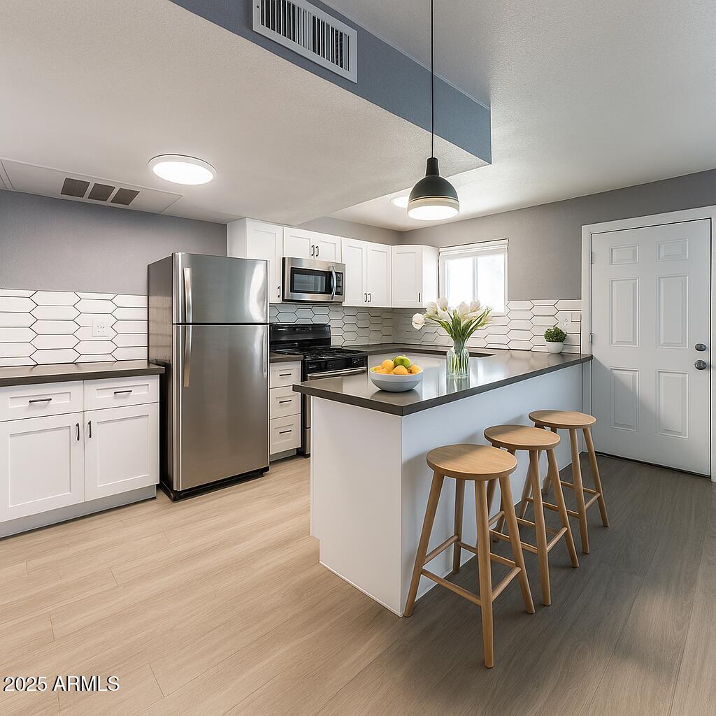 2014 West Berridge Lane Phoenix, AZ 85015 - Photo 14 of 23 a kitchen with kitchen island granite countertop stainless steel appliances a sink a stove a refrigerator cabinets and dining table