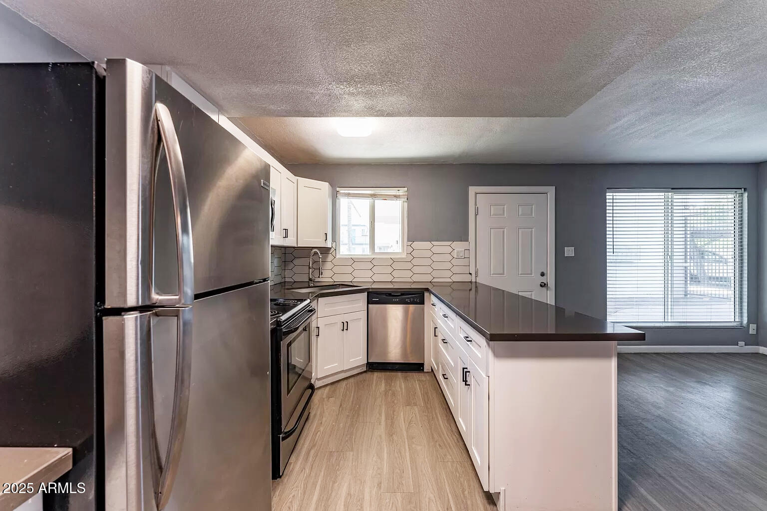2014 West Berridge Lane Phoenix, AZ 85015 - Photo 17 of 23 a kitchen with stainless steel appliances granite countertop a refrigerator a sink and wooden floors