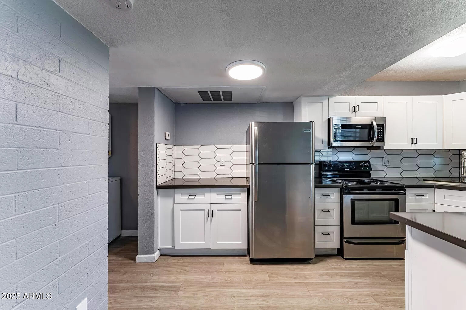 2014 West Berridge Lane Phoenix, AZ 85015 - Photo 21 of 23 a kitchen with stainless steel appliances granite countertop a refrigerator microwave and stove top oven