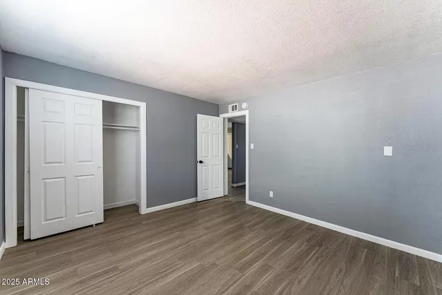 a view of an empty room with wooden floor
