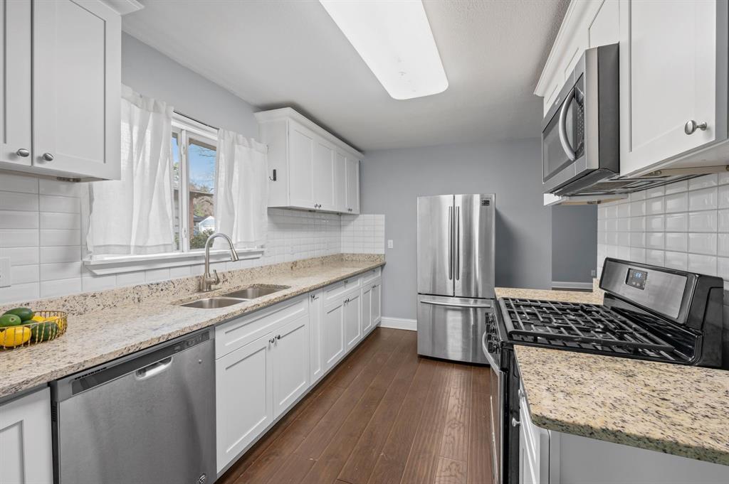 904 Treasure Road Garland, TX 75041 - Photo 11 of 27 a kitchen with a sink stove and cabinets
