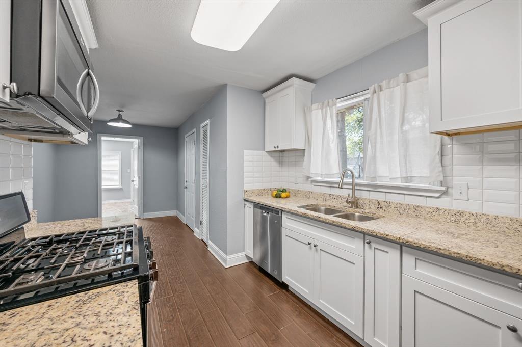 904 Treasure Road Garland, TX 75041 - Photo 12 of 27 a kitchen with a sink stove and cabinets