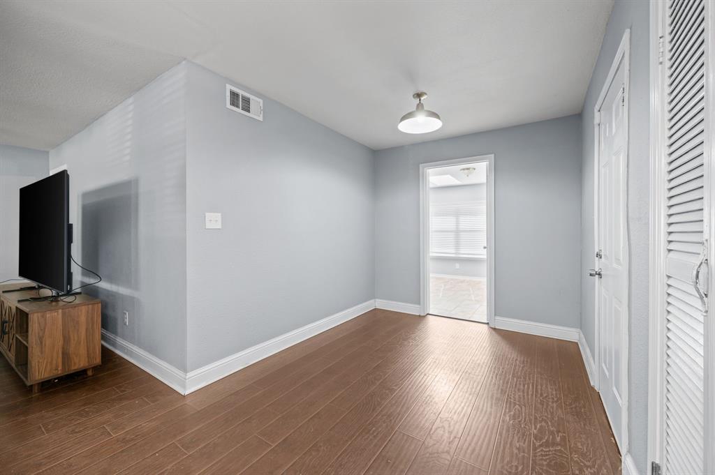 904 Treasure Road Garland, TX 75041 - Photo 14 of 27 a view of a livingroom with wooden floor and a flat screen tv