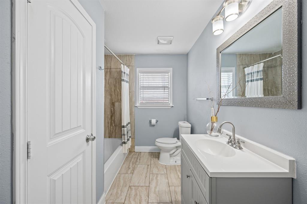 904 Treasure Road Garland, TX 75041 - Photo 22 of 27 a bathroom with a sink a toilet and a mirror