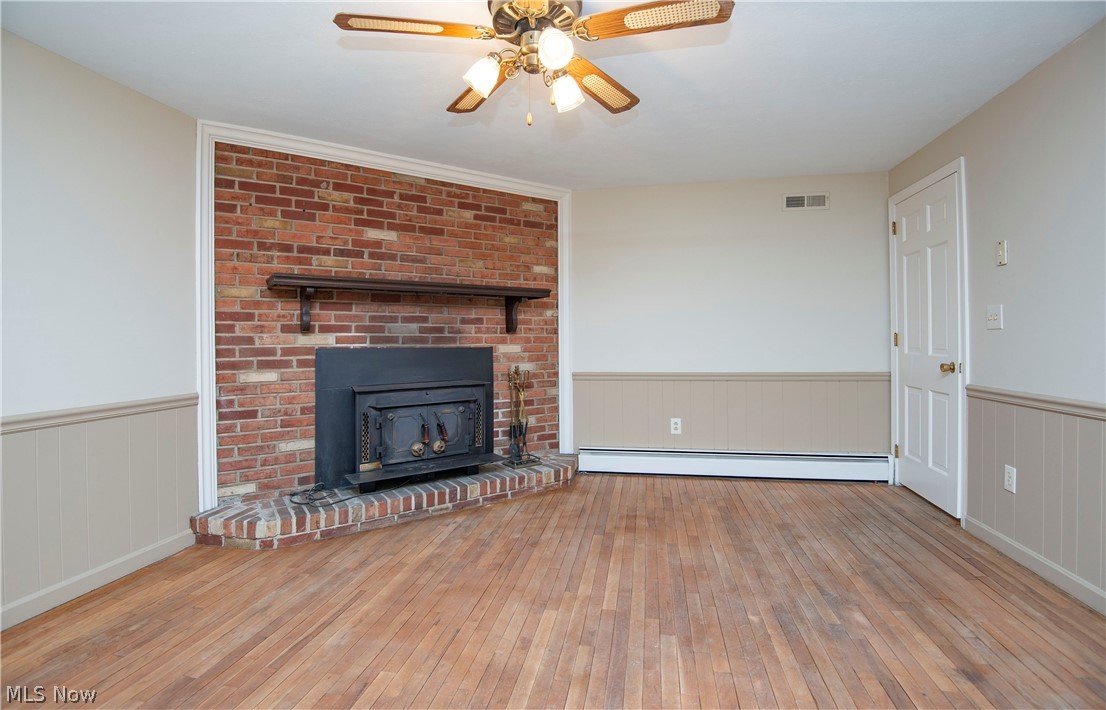 The family-room features natural hardwood flooring and third wood-burning fireplace with stove insert. The door you see leads to the small back hall with powder room,coat closest and the 2 car garage.