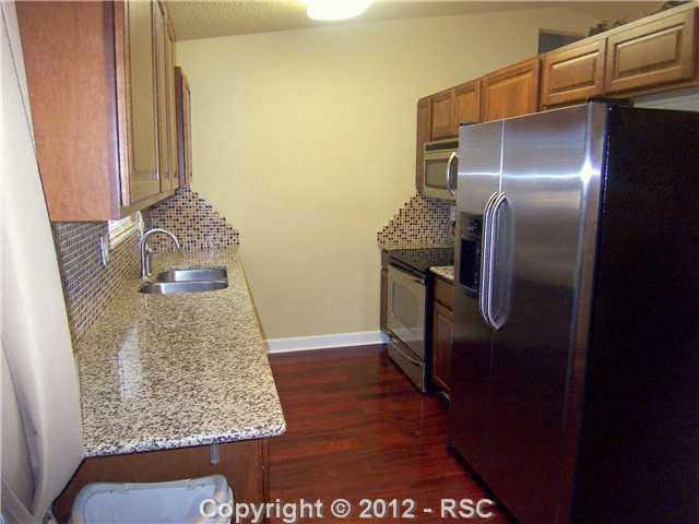 7212 River Bend Road Colorado Springs, CO 80911 - Photo 8 of 22 Stainless Appliances, Dark Wood Floor, Plenty of Work Space