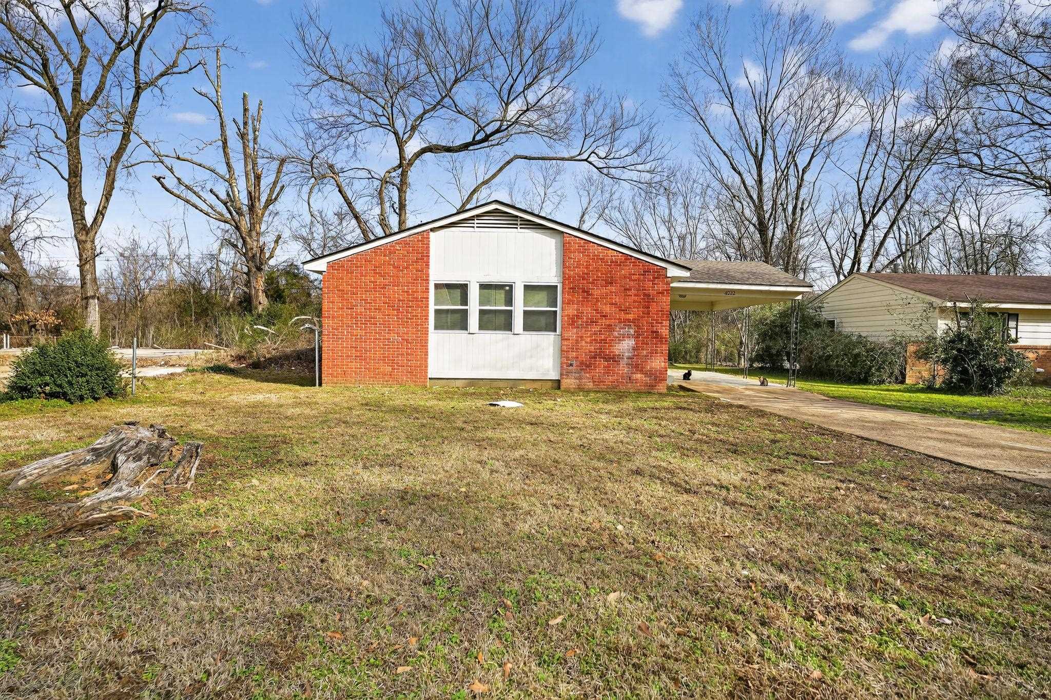 4212 Falcon Drive Memphis, TN 38109 - Photo 18 of 31 View of side of home featuring a yard, driveway, and a carport