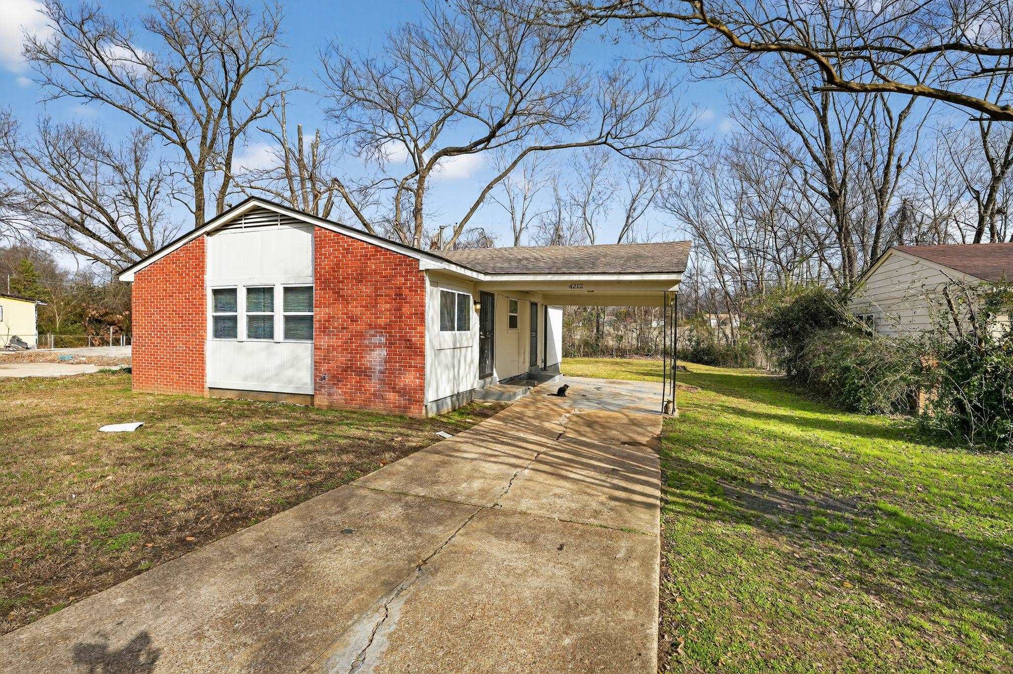 4212 Falcon Drive Memphis, TN 38109 - Photo 19 of 31 View of front of house featuring a front yard, an attached carport, concrete driveway, and brick siding
