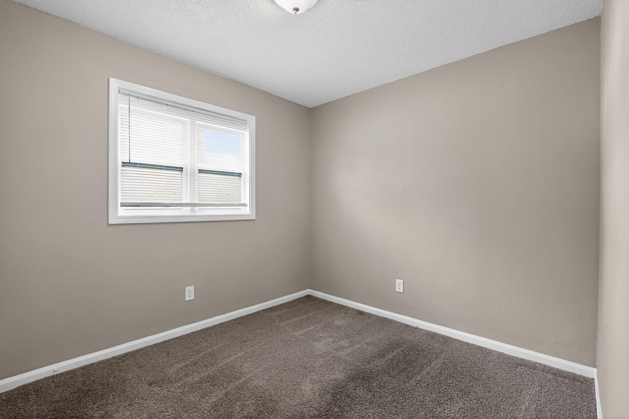 4212 Falcon Drive Memphis, TN 38109 - Photo 4 of 31 Carpeted spare room with baseboards and a textured ceiling