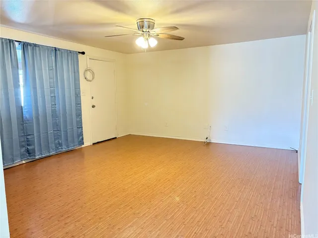 an empty room with a ceiling fan and carpet