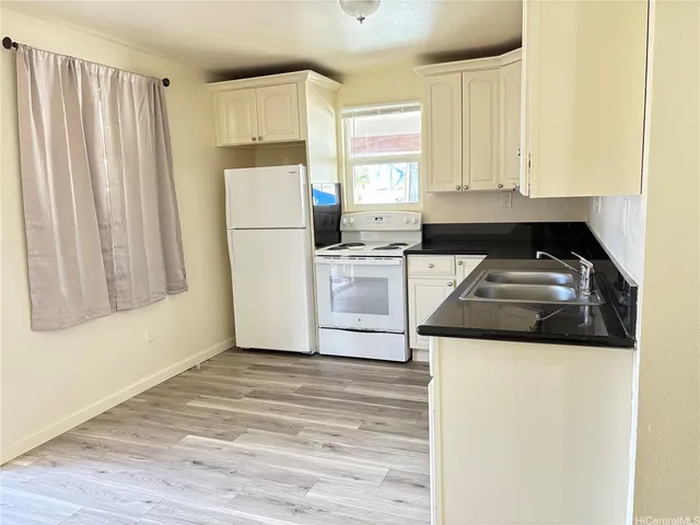 a kitchen with a stove a sink and a refrigerator