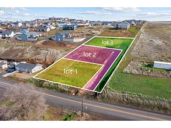 an aerial view of a tennis ground and a cars park side of the road