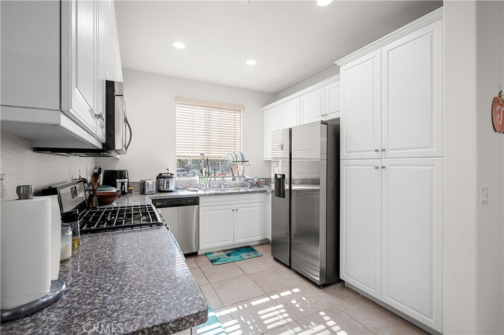 8652 Cava Drive Rancho Cucamonga, CA 91730 - Photo 11 of 28 a kitchen with a refrigerator and white cabinets