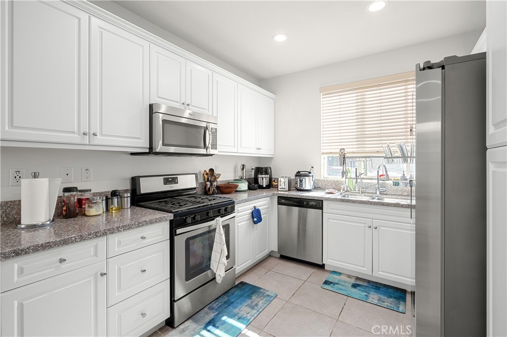 8652 Cava Drive Rancho Cucamonga, CA 91730 - Photo 9 of 28 a kitchen with granite countertop white cabinets and white appliances