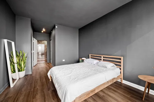 a bedroom with a bed lamps and wooden floor