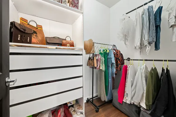 a view of walk in closet with clothes and shoes