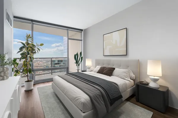 a bedroom with a bed lamp and a potted plant