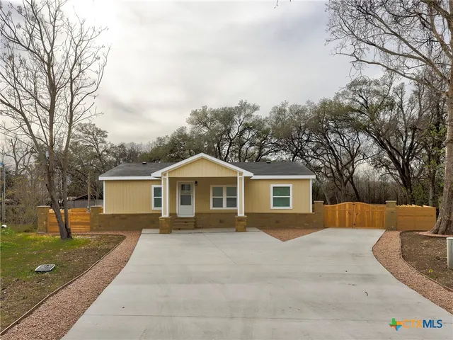 a front view of a house with a yard and trees