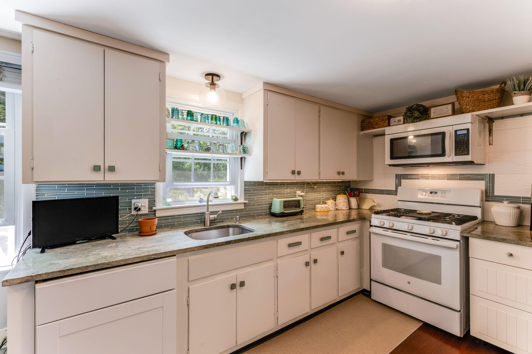 4975 State Highway, Unit A Eastham, MA 02642 - Photo 11 of 44 a kitchen with granite countertop white cabinets and white appliances