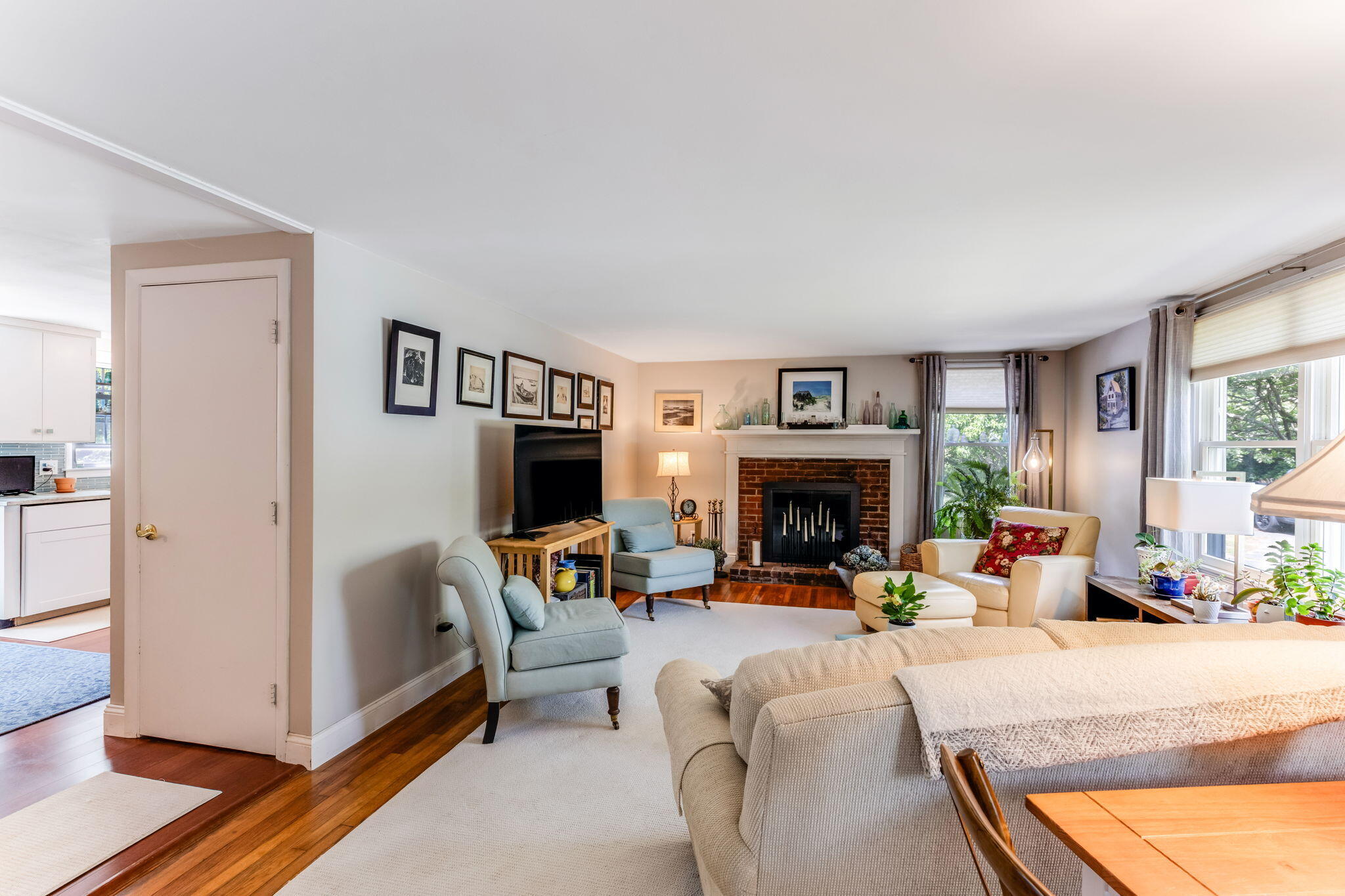 4975 State Highway, Unit A Eastham, MA 02642 - Photo 23 of 44 a living room with furniture a fireplace and a large window with garden view