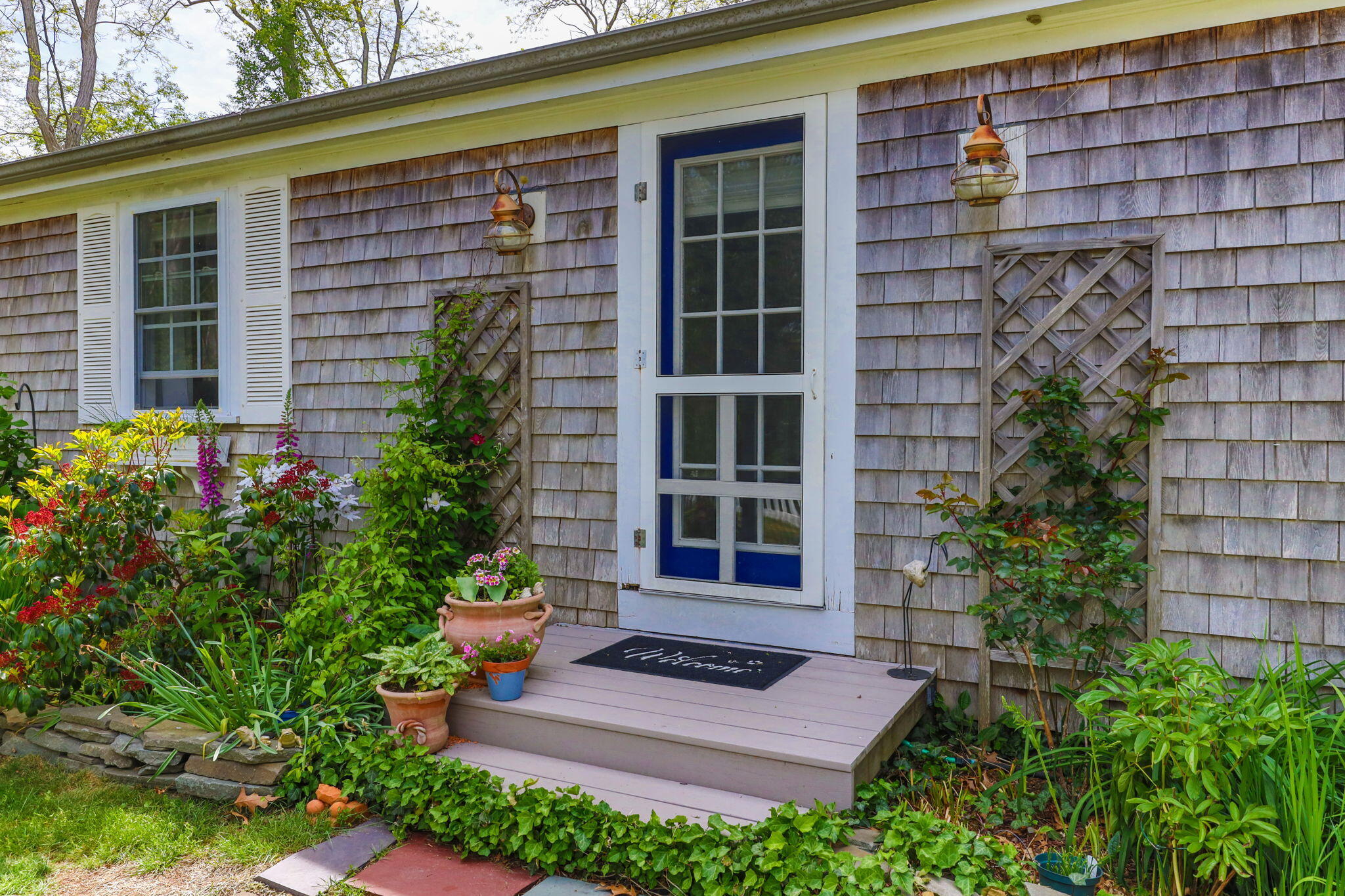 4975 State Highway, Unit A Eastham, MA 02642 - Photo 3 of 44 front view of a brick house with a large windows and flower plants
