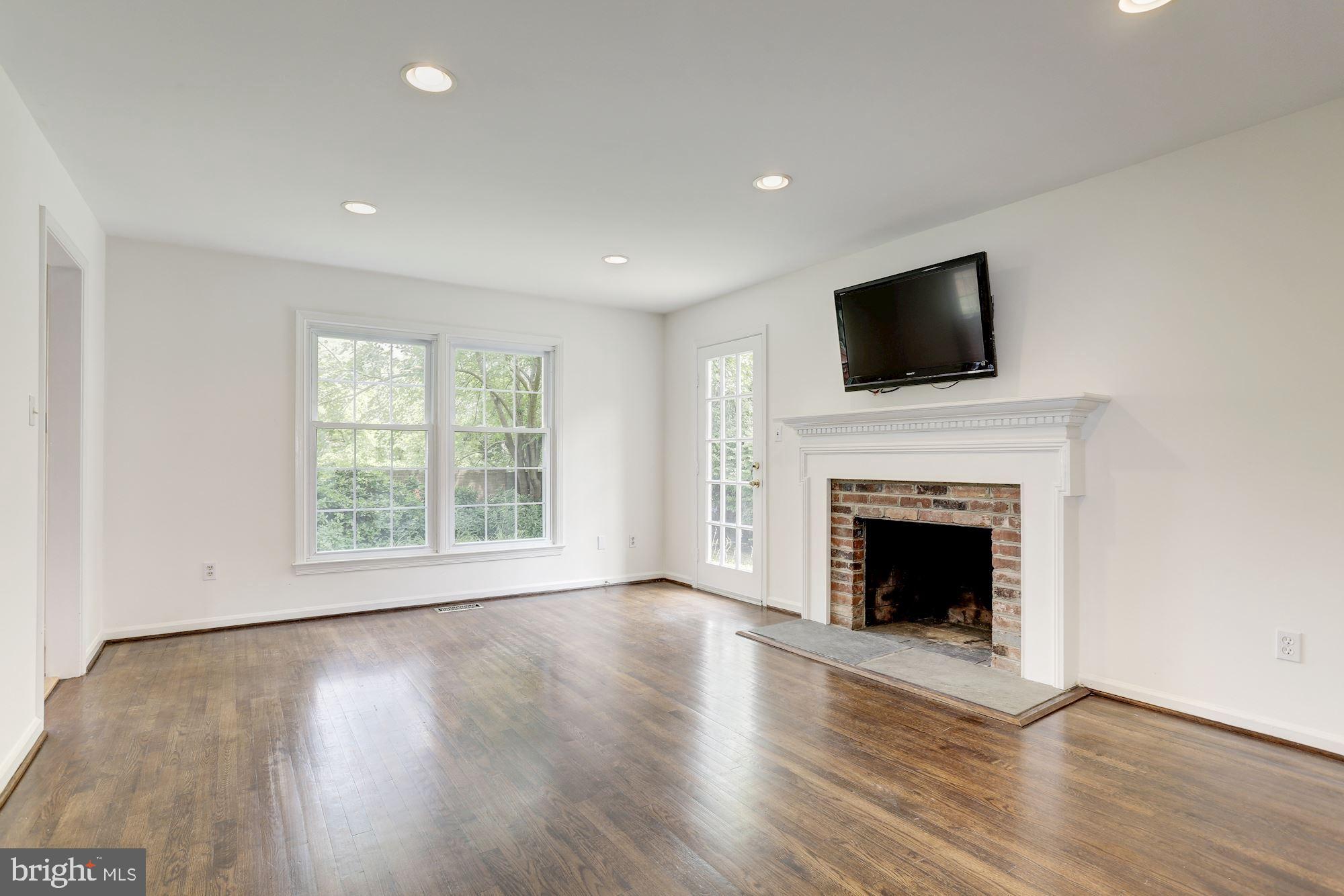 10239 Gainsborough Road Potomac, MD 20854 - Photo 11 of 21 a view of an empty room with wooden floor fireplace and a window