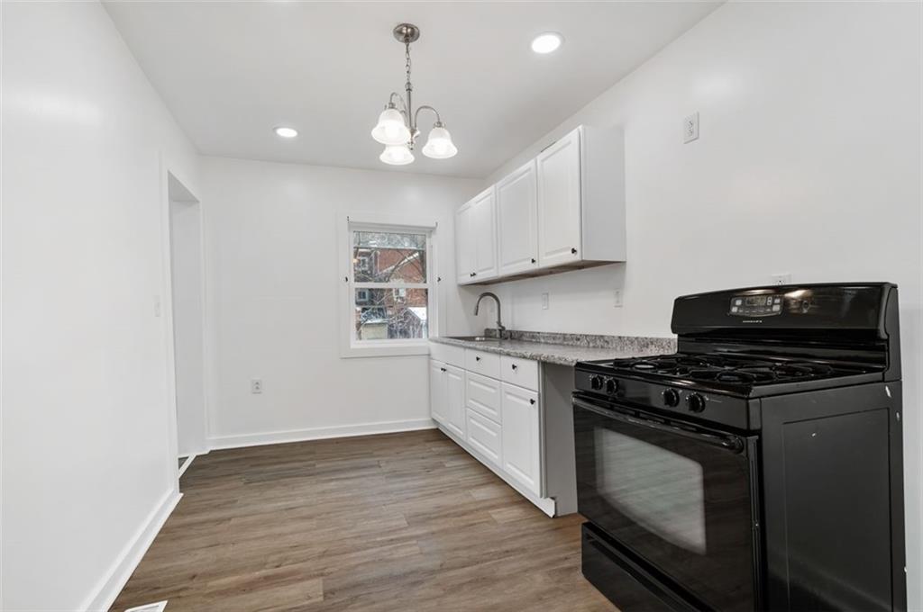 1619 Haug Street Pittsburgh, PA 15212 - Photo 9 of 27 a kitchen with granite countertop wooden cabinets and a stove